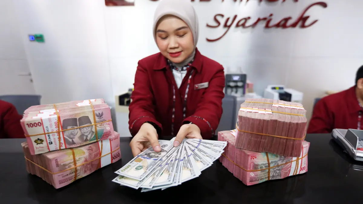 Karyawan menunjukkan uang pecahan rupiah dan dolar Amerika Serikat (AS) di gerai penukaran mata uang asing di Jakarta. (Dery Ridwansah/ JawaPos.com)