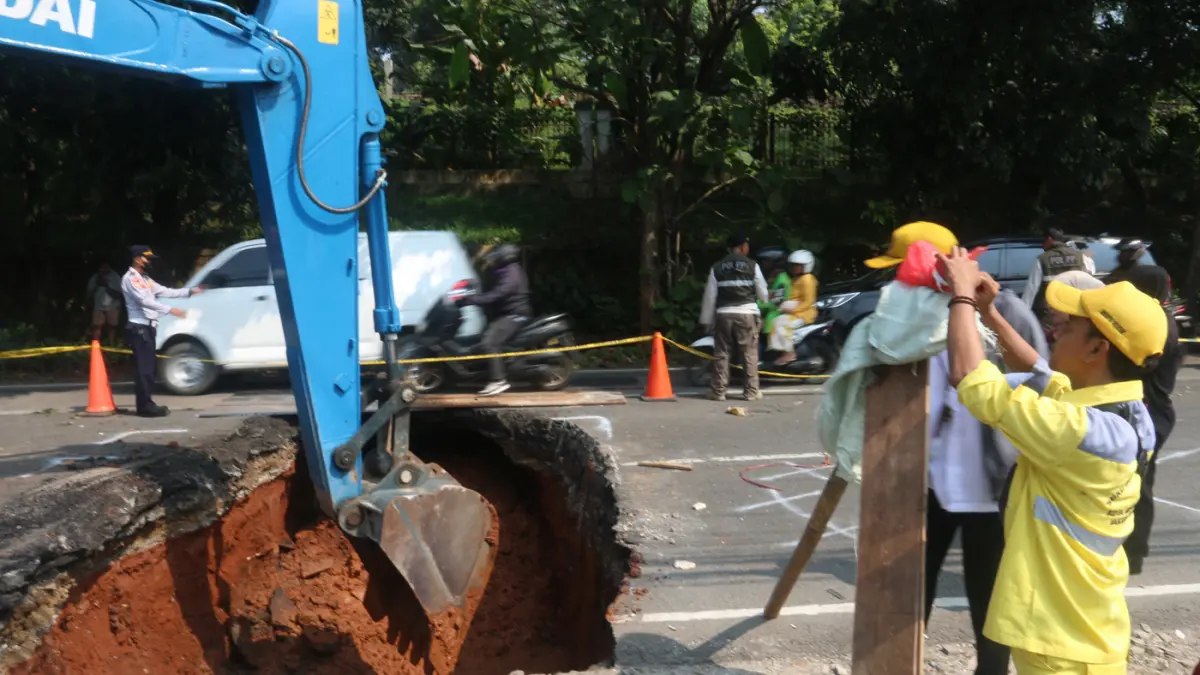 Petugas memperbaiki kondisi jalan yang amblas di Jalan Raya Lenteng Agung, Jakarta Selatan, Jumat (29/5/2026). (Dery Ridwansah/ JawaPos.com)