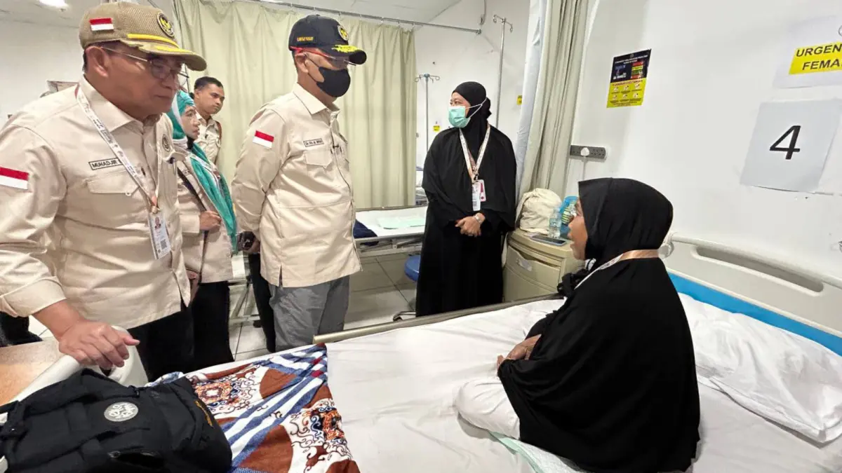 Menteri Haji dan Umrah RI Mochamad Irfan Yusuf (pakai masker hitam) berbincang dengan jamaah haji Indonesia yang dirawat di Klinik Kesehatan Haji Indonesia. (Media Center Haji 2026) - Image