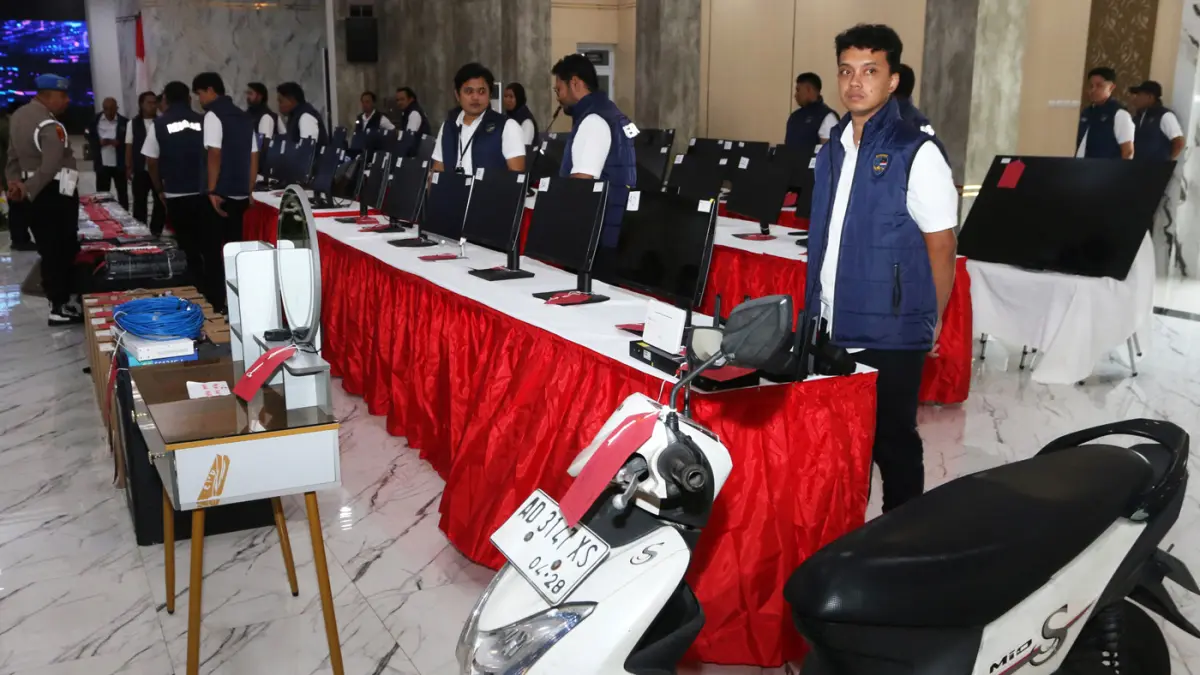 Penyidik berada di dekat barang bukti dalam rilis pengungkapan kasus dugaan penipuan daring dengan modus pig butchering di Polda Jawa Tengah, Semarang, Jawa Tengah, Senin (1/6/2026). (Nur Chamim/ Jawa Pos Radar Semarang)