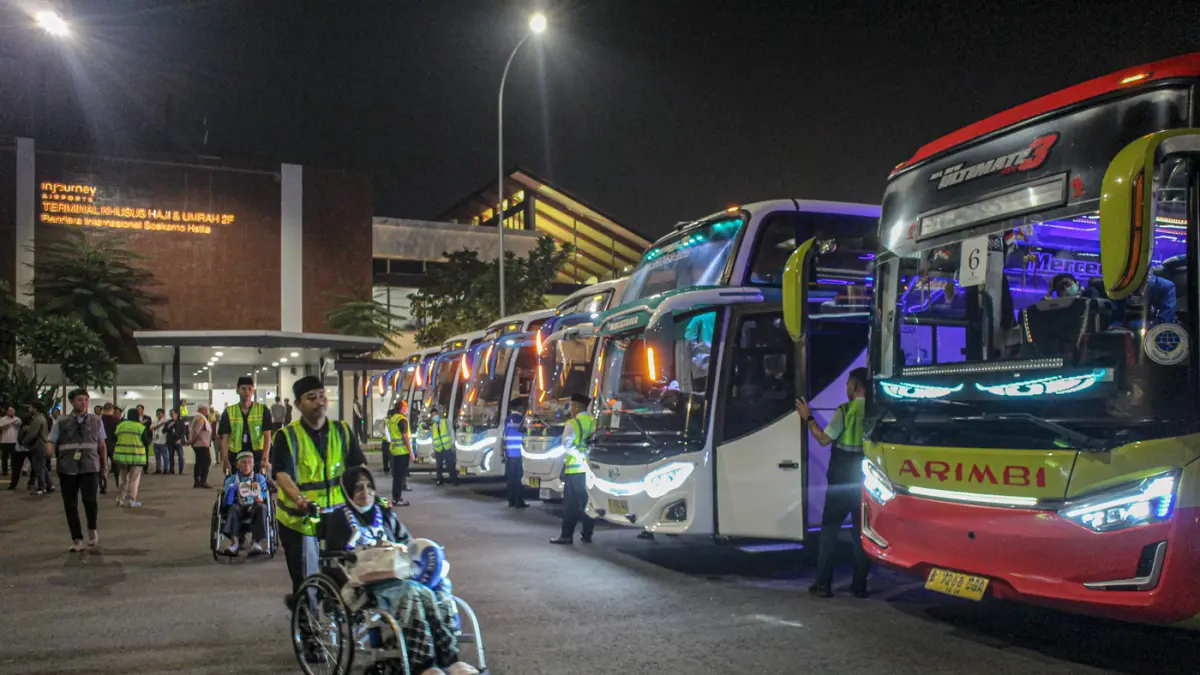 Sejumlah jamaah haji Debarkasi Jakarta Pondok Gede (JKG) diantar petugas menuju bus usai tiba di Terminal 2F, Bandara Soekarno-Hatta, Tangerang, Senin (01/06/2026). (Hanung Hambara/Jawa Pos)