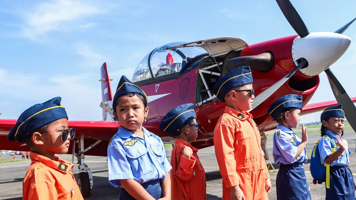 Sejumlah siswa TK Angkasa melihat pesawat usai para penerbang yang tergabung dalam Jupiter Aerobatic Team (JAT) dari TNI-AU membawa pesawat berjenis KT-1B Woong Bee saat landing di Join Base Ops Lanudal Juanda, Jumat (5/6/2026). (Riana Setiawan/ Jawa Pos)