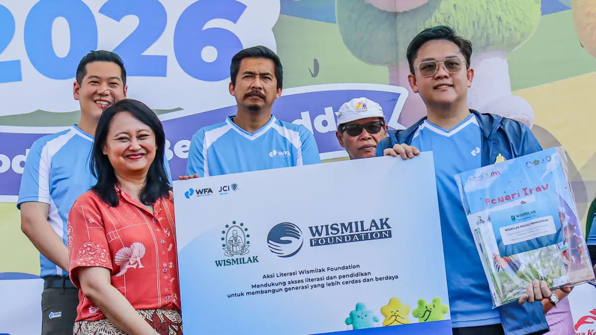 Perwakilan Wismillak Foundation, Anastesya Ftaraya (kiri) secara simbolis menyalurkan ribuan buku kepada Local President CJI East Java, Alfin Vado Fransen dalam Walk For Autism festival 2026 di Lapangan Rektorat Unesa, Surabaya, Minggu (7/6) . (Riana Seti
