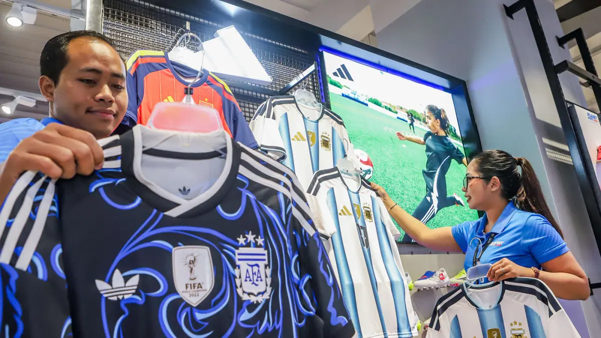 Pekerja menata koleksi jersey World Cup 2026 di Planet Sports Ciputra World Surabaya, Jalan Mayjen Sungkono, Selasa (9/6). (Riana Setiawan/ Jawa Pos)