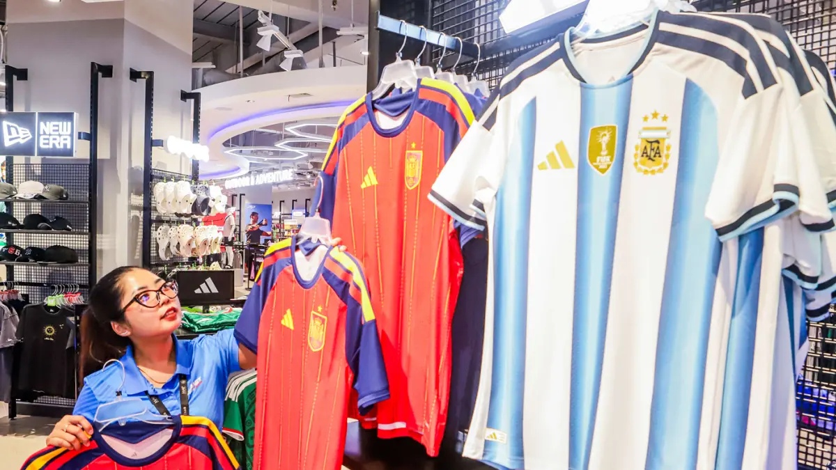 Pekerja menata koleksi jersey World Cup 2026 di Planet Sports Ciputra World Surabaya, Jalan Mayjen Sungkono, Selasa (9/6). (Riana Setiawan/ Jawa Pos)