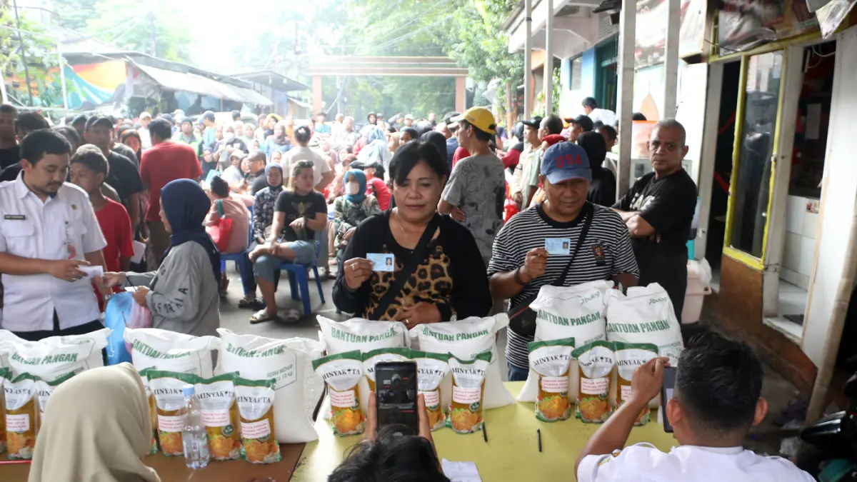 Petugas memberikan beras saat pendistribusian bantuan pangan berupa beras dan minyak goreng, di Balai RW 03 Menteng, Jakarta, Rabu (10/6/2026). (Dery Ridwansah/ JawaPos.com)