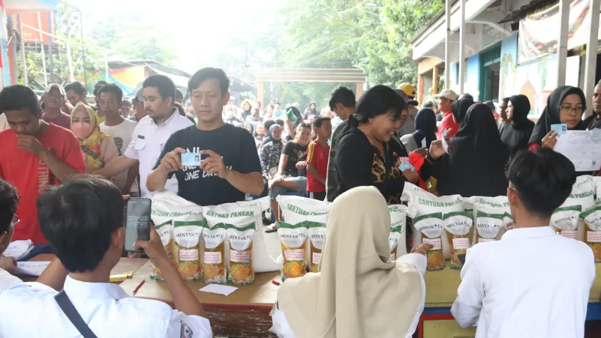 Petugas memberikan beras saat pendistribusian bantuan pangan berupa beras dan minyak goreng, di Balai RW 03 Menteng, Jakarta, Rabu (10/6/2026). (Dery Ridwansah/ JawaPos.com)