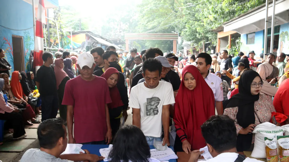Petugas memberikan beras saat pendistribusian bantuan pangan berupa beras dan minyak goreng, di Balai RW 03 Menteng, Jakarta, Rabu (10/6/2026). (Dery Ridwansah/ JawaPos.com)