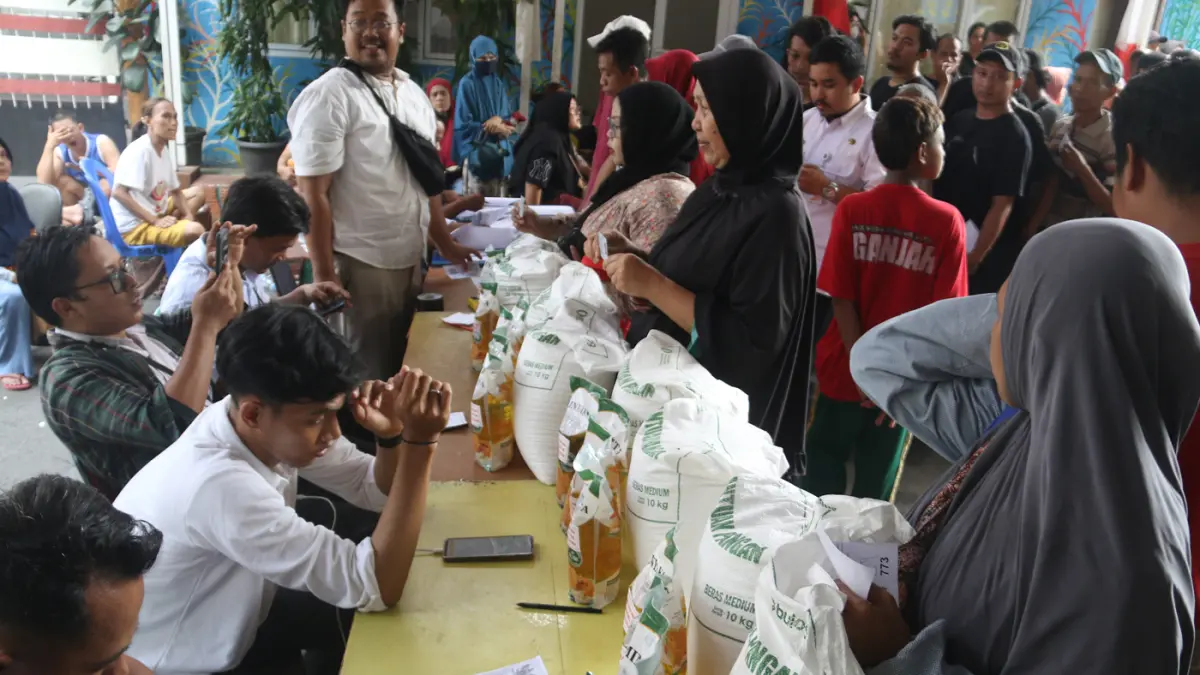 Petugas memberikan beras saat pendistribusian bantuan pangan berupa beras dan minyak goreng, di Balai RW 03 Menteng, Jakarta, Rabu (10/6/2026). (Dery Ridwansah/ JawaPos.com)