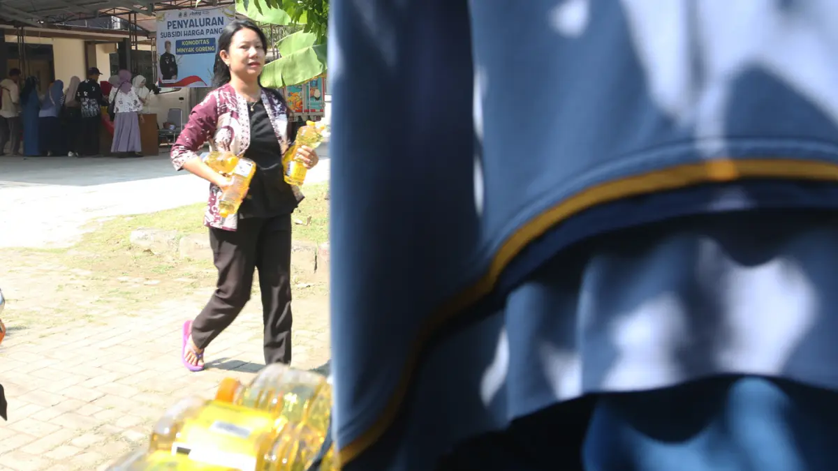 Petugas melayani warga membeli minyak goreng dalam program penyaluran subsidi harga pangan komoditas minyak goreng di Kantor Kecamatan Genuk, Semarang, Jawa Tengah, Kamis (11/6/2026). (Nur Chamim/Jawa Pos Radar Semarang)