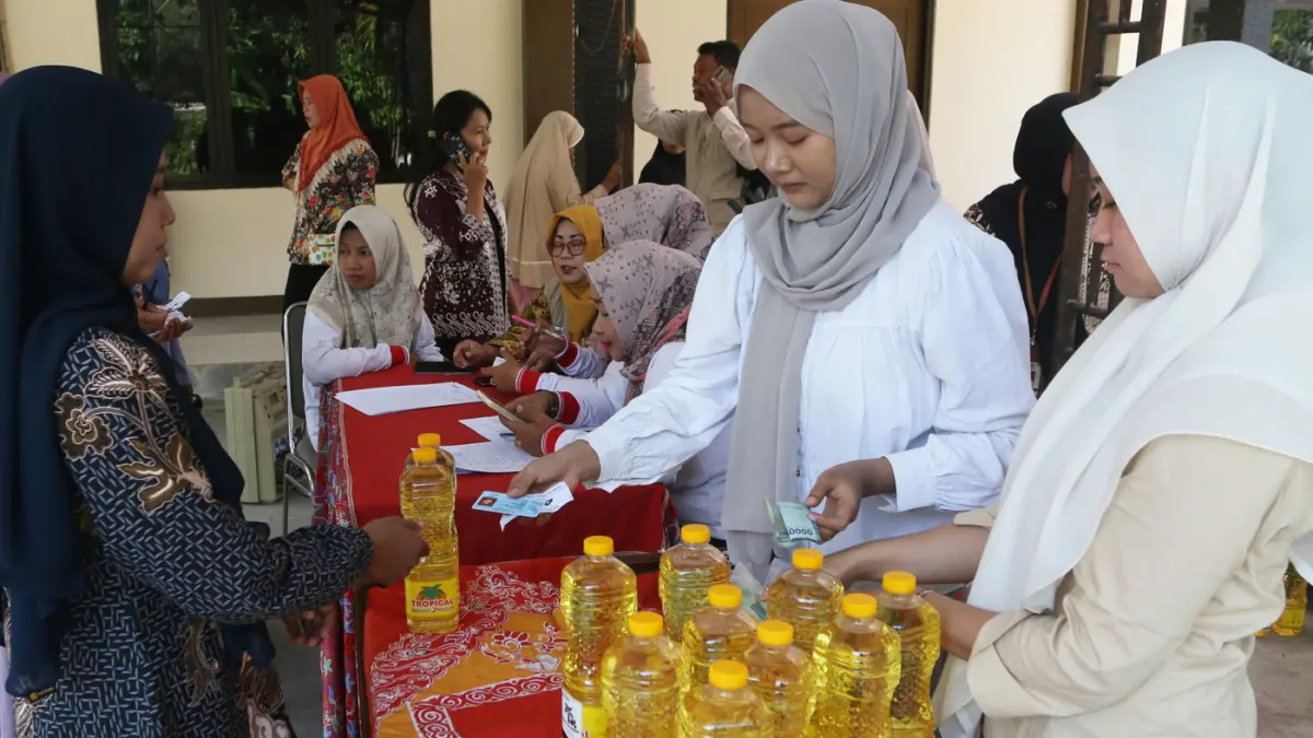 Petugas melayani warga membeli minyak goreng dalam program penyaluran subsidi harga pangan komoditas minyak goreng di Kantor Kecamatan Genuk, Semarang, Jawa Tengah, Kamis (11/6/2026). (Nur Chamim/Jawa Pos Radar Semarang)