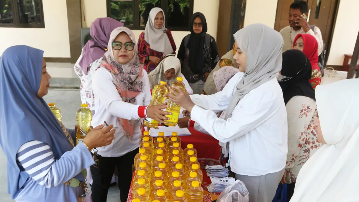 Petugas melayani warga membeli minyak goreng dalam program penyaluran subsidi harga pangan komoditas minyak goreng di Kantor Kecamatan Genuk, Semarang, Jawa Tengah, Kamis (11/6/2026). (Nur Chamim/Jawa Pos Radar Semarang)