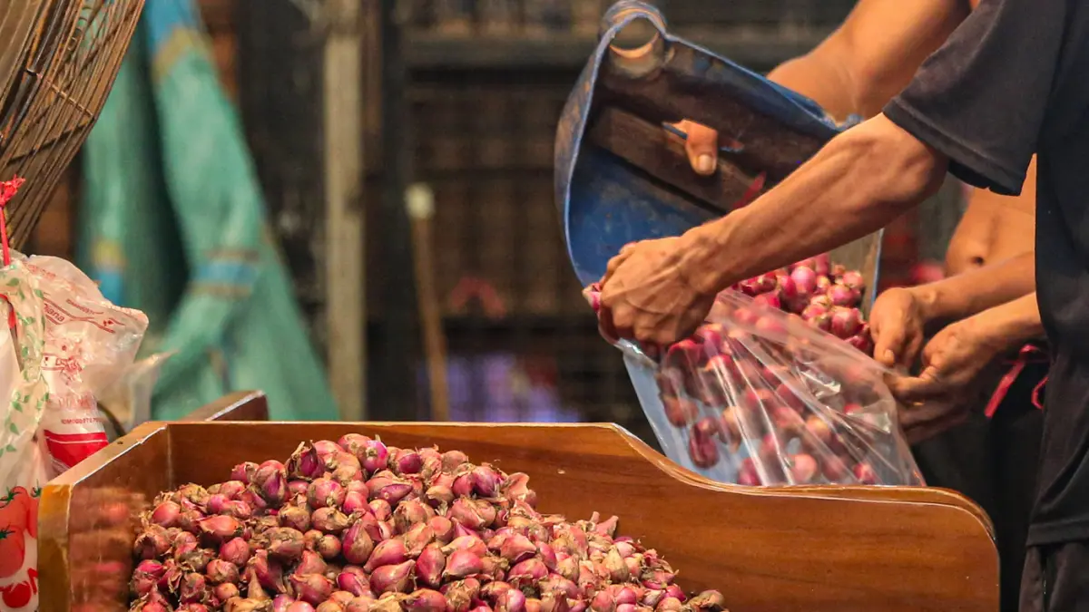 Pekerja membawa bawang merah di Pasar Induk Keramat Jati, Jakarta, Selasa (16/6/2026). (Salman Toyibi/Jawa Pos)