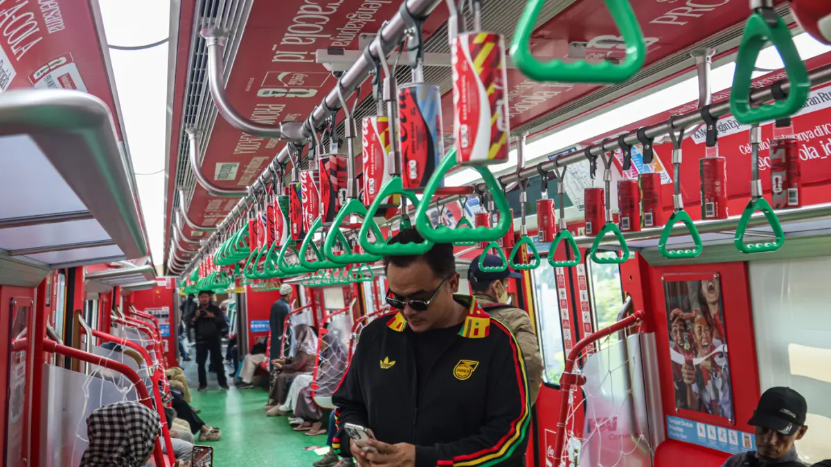Sejumlah penumpang melihat gerbong KRL dengan livery Piala Dunia 2026 di Jakarta, Rabu (17/06/2026). (Dery Ridwansah/ JawaPos.com)