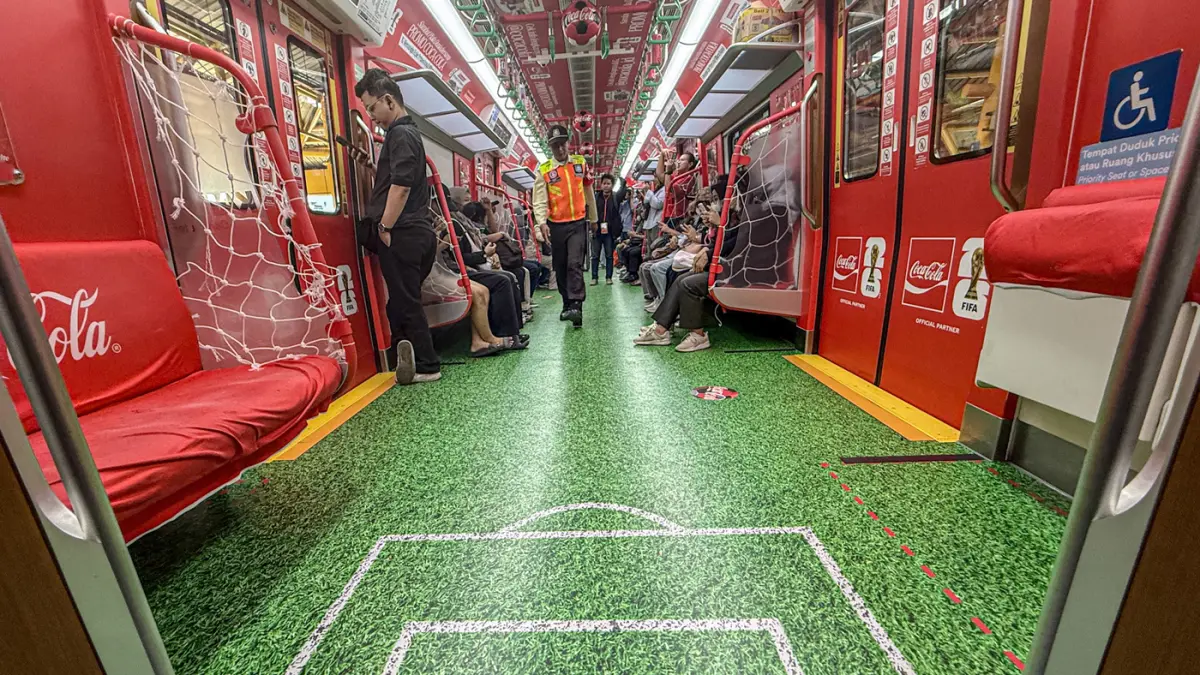 Sejumlah penumpang melihat gerbong KRL dengan livery Piala Dunia 2026 di Jakarta, Rabu (17/06/2026). (Dery Ridwansah/ JawaPos.com)