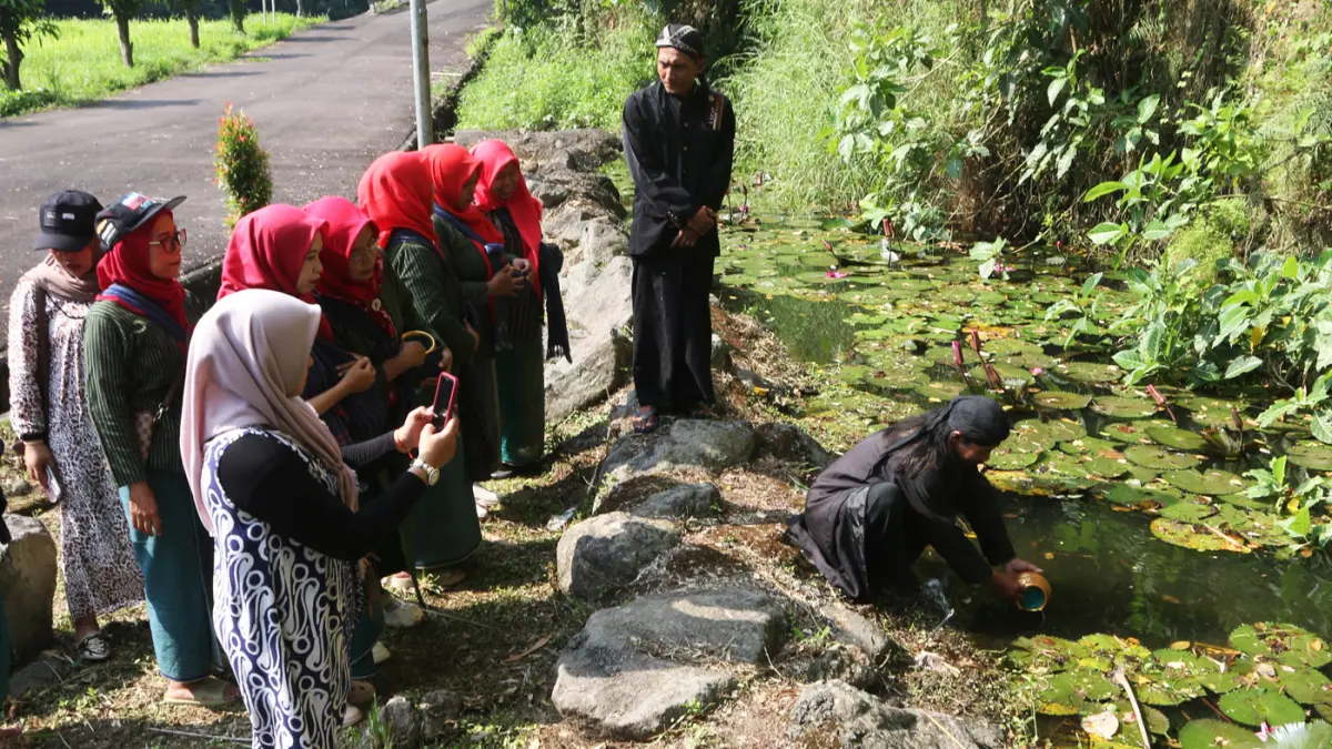 Sejumlah warga membawa kendi berisi air dalam prosesi tradisi pengambilan tujuh sumber tirta (air suci) di Desa Wisata Goa Kreo, Gunung Pati, Semarang, Jawa Tengah, Minggu (14/6/2026). (Nur Chamim/Jawa Pos Radar Semarang)