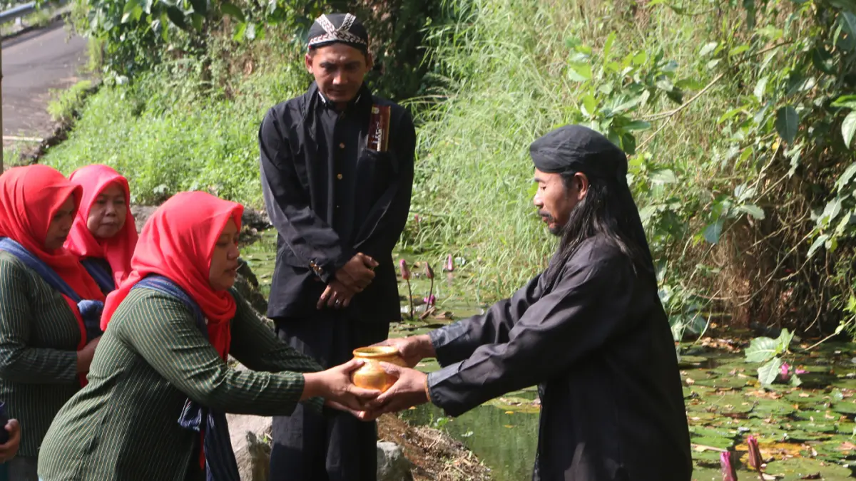 Sejumlah warga membawa kendi berisi air dalam prosesi tradisi pengambilan tujuh sumber tirta (air suci) di Desa Wisata Goa Kreo, Gunung Pati, Semarang, Jawa Tengah, Minggu (14/6/2026). (Nur Chamim/Jawa Pos Radar Semarang)