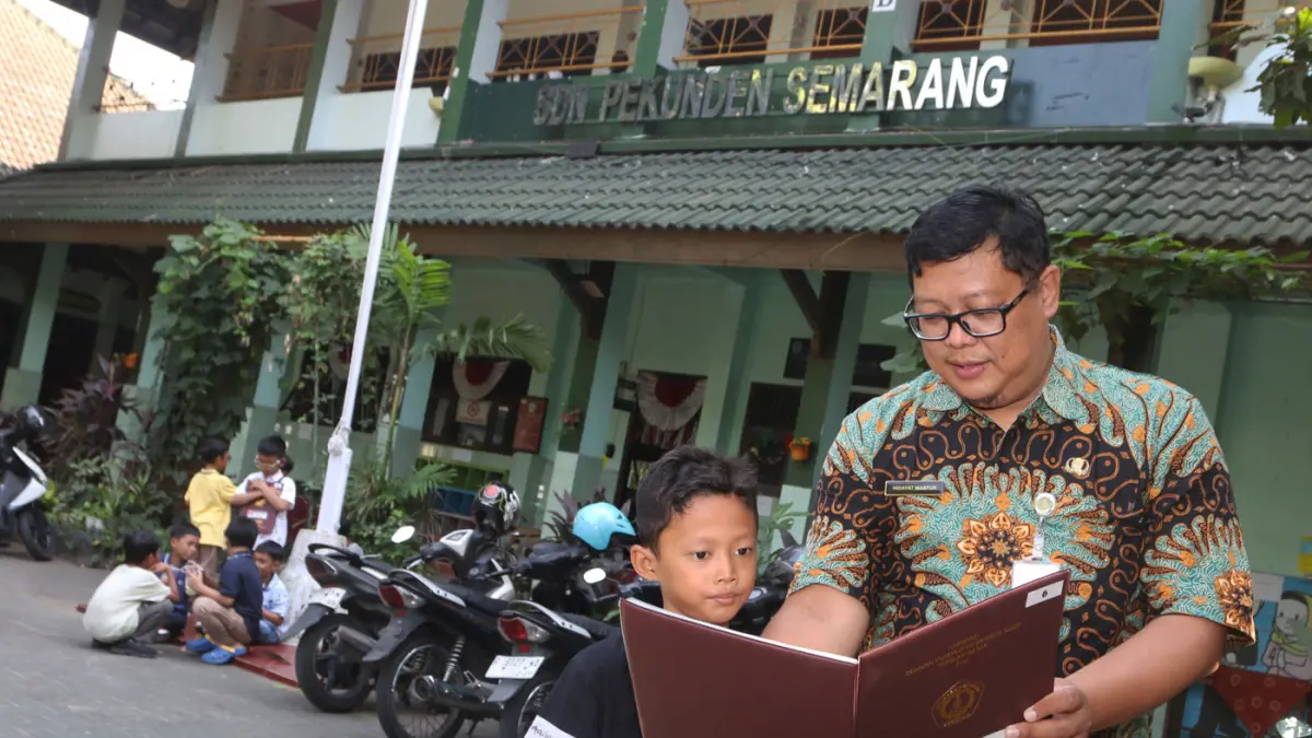 Guru melayani Ayah mengambil rapor di SD Pekunden, Kota Semarang,Jawa Tengah, Jumat (19/6/2026). (Nur Chamim/Jawapos Radar Semarang)
