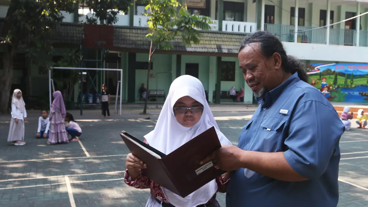 Guru melayani Ayah mengambil rapor di SD Pekunden, Kota Semarang,Jawa Tengah, Jumat (19/6/2026). (Nur Chamim/Jawapos Radar Semarang)