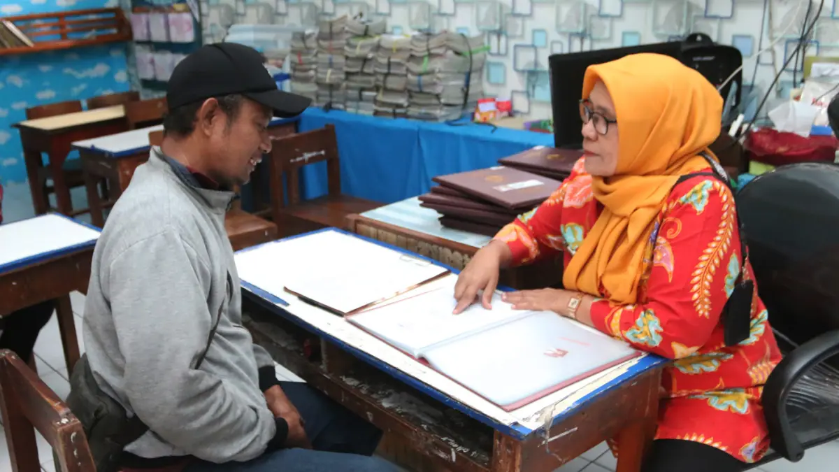 Guru melayani Ayah mengambil rapor di SD Pekunden, Kota Semarang,Jawa Tengah, Jumat (19/6/2026). (Nur Chamim/Jawapos Radar Semarang)