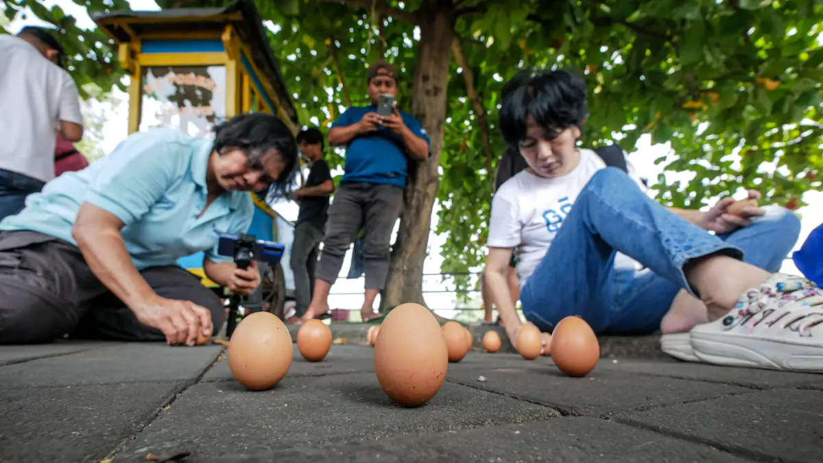 Sejumlah warga berpatrisipasi mendirikan telur saat perayaan Peh Cun di pinggir Sungai Cisadane, Kota Tangerang, Jumat (19/06/2026). (Hanung Hambara/Jawa Pos)