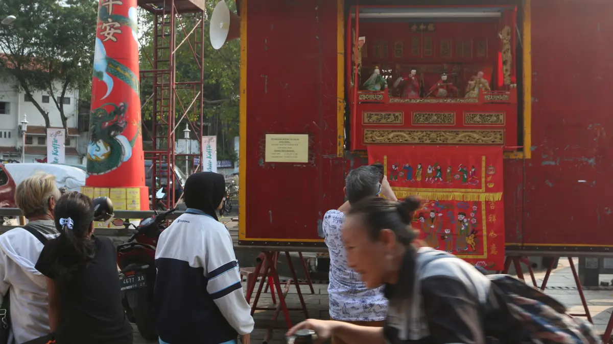 Sejumlah warga menyaksikan pertunjukan Wayang Potehi di halaman Kelenteng TTID Tay Kak Sie, Kota Semarang, Jawa Tengah, Sabtu (20/6/2026) sore. (Nur Chamim/Jawa Pos Radar Semarang)