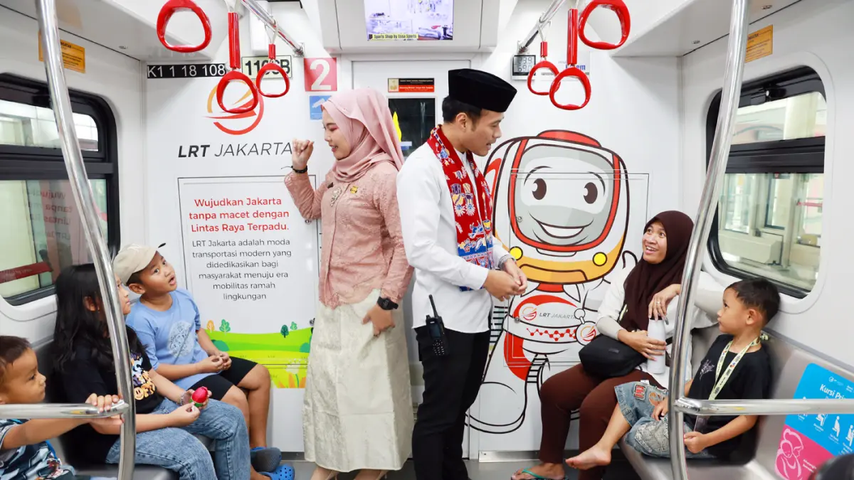 Karyawan menyapa pengguna LRT Jakarta saat memanfaatkan tarif spesial Rp. 1 LRT Jakarta yang berlaku pada perayaan HUT ke-499 Kota Jakarta di Stasiun Velodrome.