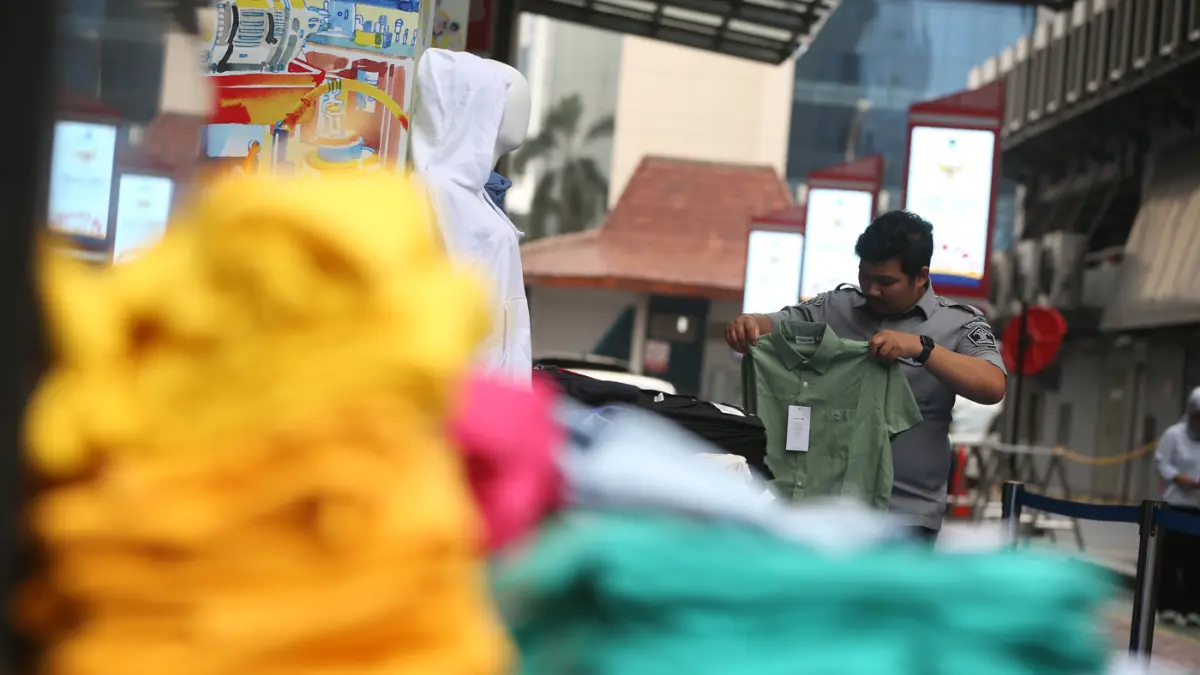 Petugas menunjukkan baju bermerk Lacoste palsu sebelum dimusnahkan di kantor Direktorat Jenderal Kekayaan Intelektual (DJKI) pada Kementerian Hukum (Kemenkum) di Jakarta, Senin (22/6/2026). (Dery Ridwansah/ JawaPos.com)