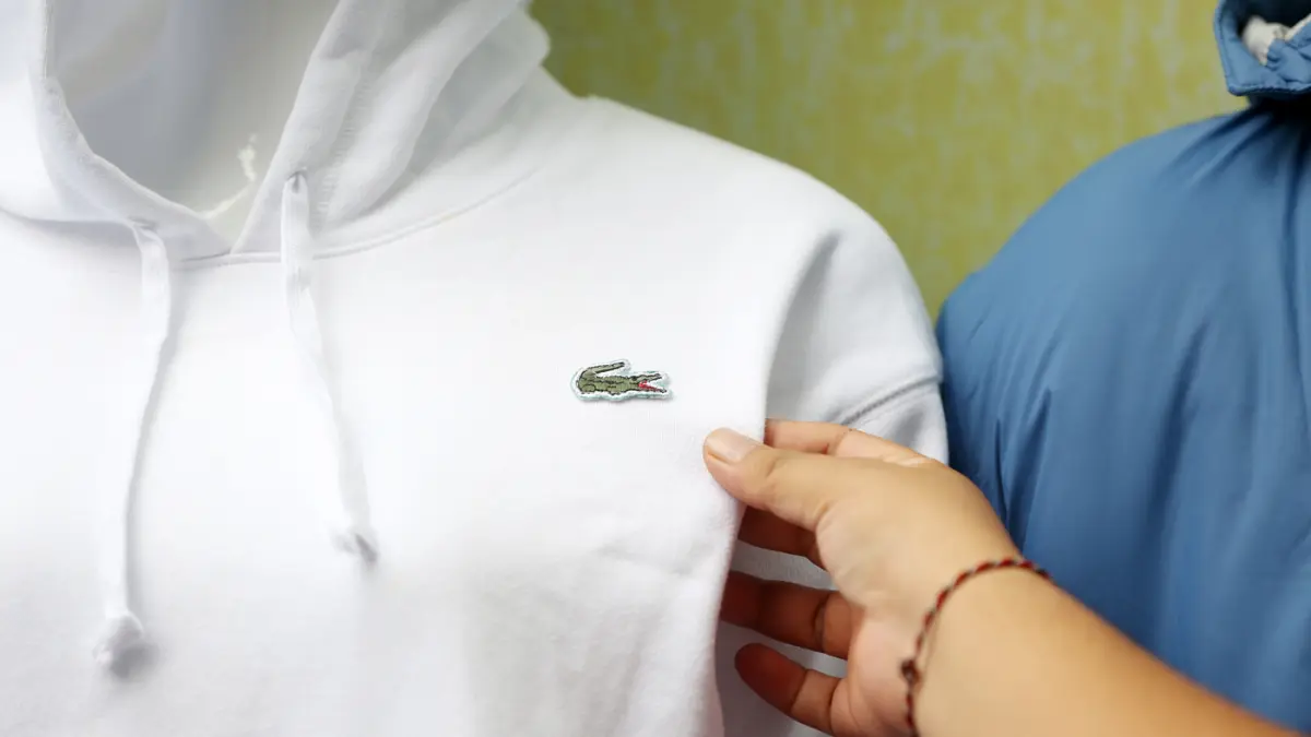 Petugas menunjukkan baju bermerk Lacoste palsu sebelum dimusnahkan di kantor Direktorat Jenderal Kekayaan Intelektual (DJKI) pada Kementerian Hukum (Kemenkum) di Jakarta, Senin (22/6/2026). (Dery Ridwansah/ JawaPos.com)
