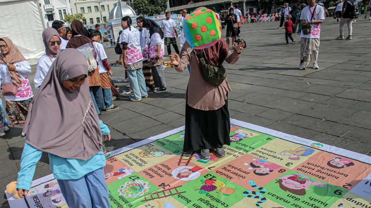 Sejumlah wisatawan mencoba permainan tradisional serta menyaksikan tari dan angklung kolosal dalam acara Berkumpul dan Bermain (Berkain) di Lapangan Fatahilah, Kota Tua, Jakarta, Minggu (14/06/2026). (Hanung Hambara/ Jawa Pos)
