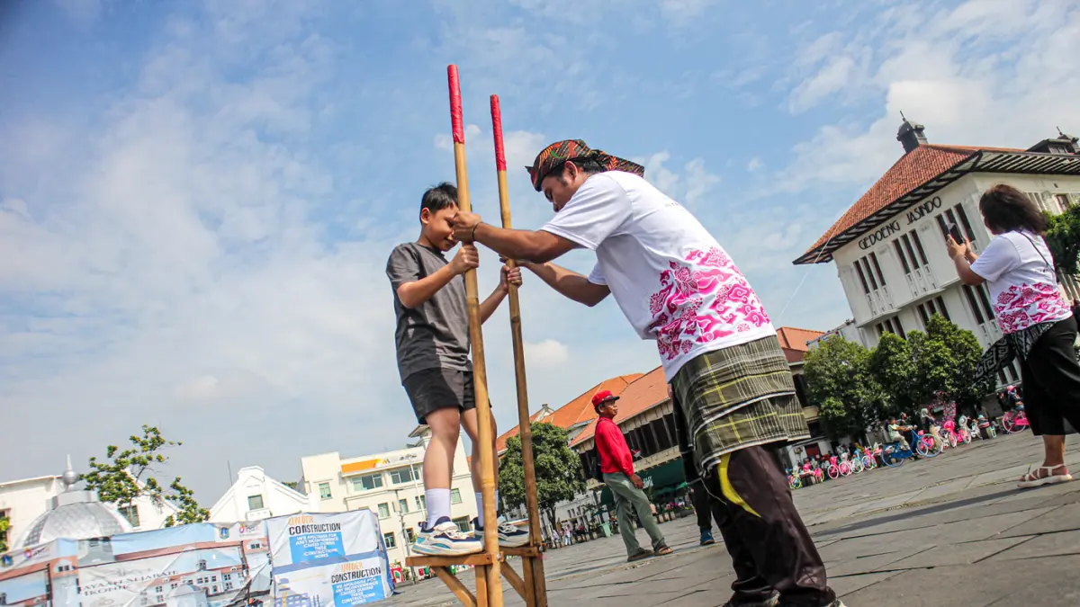 Sejumlah wisatawan mencoba permainan tradisional serta menyaksikan tari dan angklung kolosal dalam acara Berkumpul dan Bermain (Berkain) di Lapangan Fatahilah, Kota Tua, Jakarta, Minggu (14/06/2026). (Hanung Hambara/ Jawa Pos)