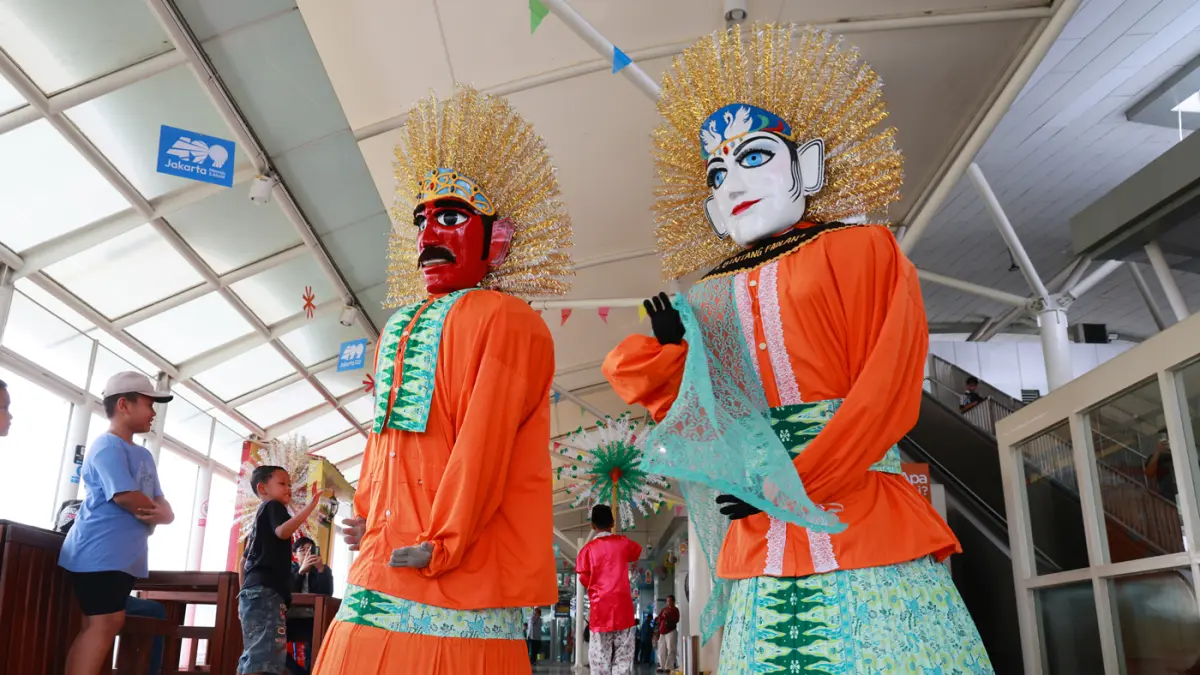Warga Jakarta berfoto didepan ornamen Rumah Betawi saat memanfaatkan tarif spesial Rp. 1 LRT Jakarta yang berlaku pada perayaan HUT ke-499 Kota Jakarta di Stasiun Velodrome.