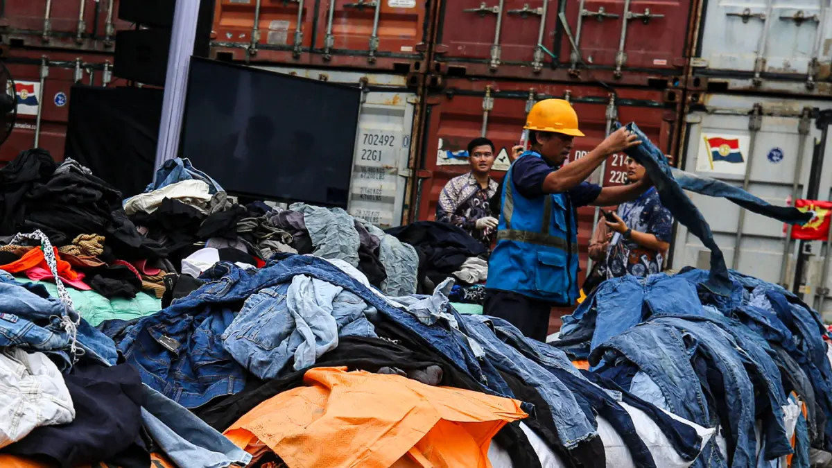 Petugas menata barang saat konferensi pers penindakan peti kemas pakaian bekas ilegal di Buffer Area TPS CDC Pelabuhan Tanjung Priok, Jakarta, Selasa (23/6/2026). (Salman Toyibi/Jawa Pos)