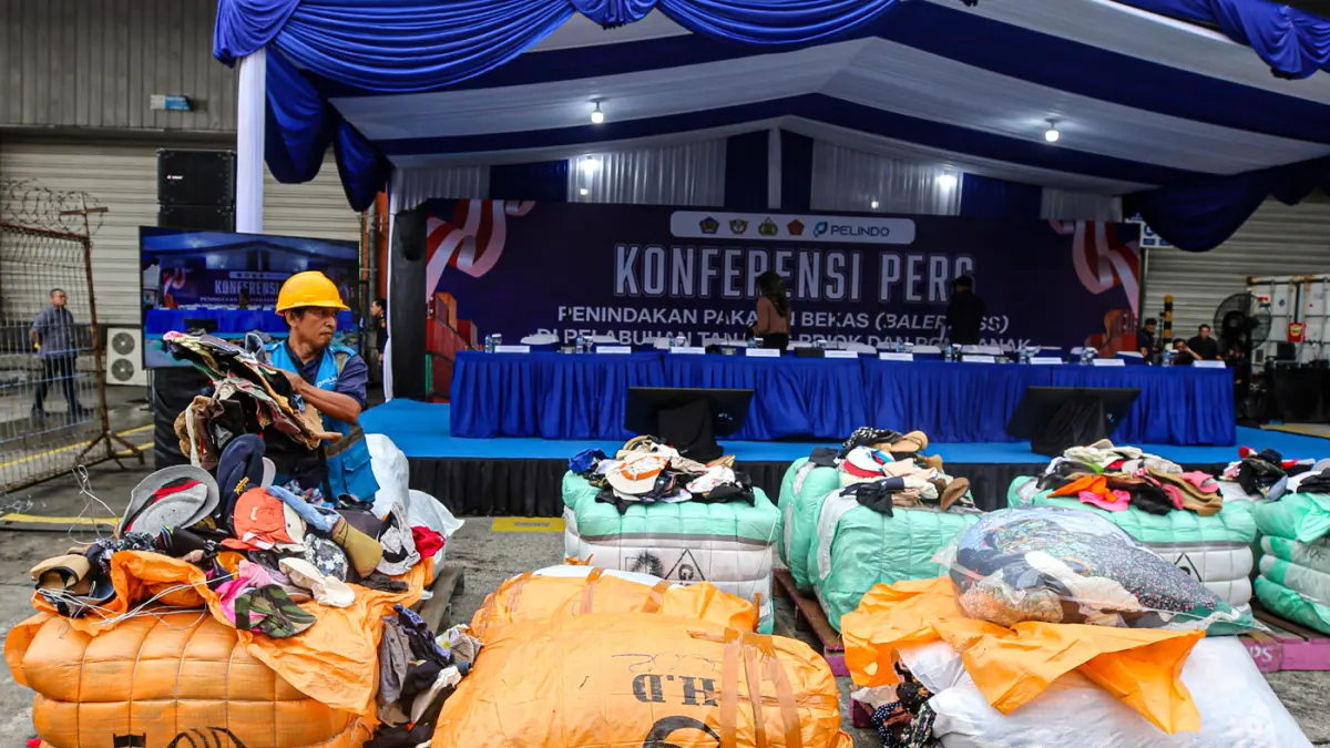Petugas menata barang saat konferensi pers penindakan peti kemas pakaian bekas ilegal di Buffer Area TPS CDC Pelabuhan Tanjung Priok, Jakarta, Selasa (23/6/2026). (Salman Toyibi/Jawa Pos)