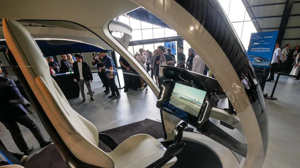 Sejumlah pengunjung melihat pesawat listrik lepas landas dan mendarat vertikal (eVTOL) buatan SkyDrive di Cerngkareng Heliport, Bandara Soekarno-Hatta, Kota Tangerang, Selasa (23/06/2026). (Hanung Hambara/Jawa Pos)