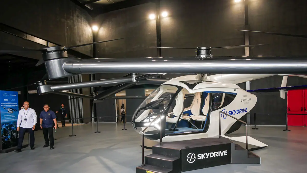 Sejumlah pengunjung melihat pesawat listrik lepas landas dan mendarat vertikal (eVTOL) buatan SkyDrive di Cerngkareng Heliport, Bandara Soekarno-Hatta, Kota Tangerang, Selasa (23/06/2026). (Hanung Hambara/Jawa Pos)