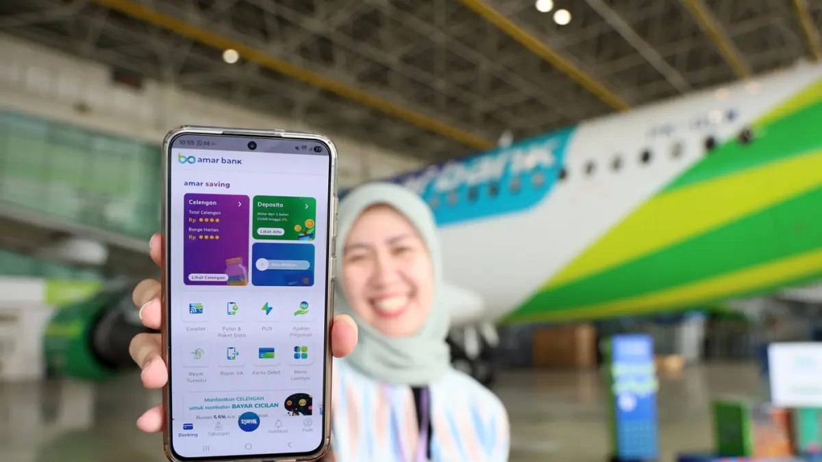 Seorang karyawan menunjukan aplikasi di sela-sela peluncuran livery khusus Amar Bank pada badan pesawat Citilink