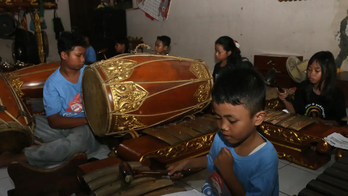 Anak-anak memainkan alat musik gamelan saat latihan seni karawitan dan pedalangan di Sindhu Laras Bocah, Semarang, Jawa Tengah, Minggu (21/6/2026). (Nur Chamim/ Jawa Pos Radar Semarang)