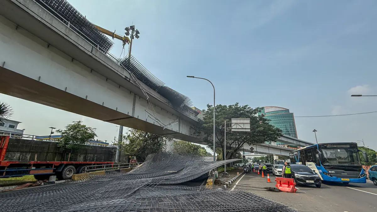 Petugas mengevakuasi muatan truk berupa wiremesh yang tumpah setelah terlibat kecelakaan tunggal di Jalan Tol Tomang, Jakarta, Rabu (24/06/2026). (Hanung Hambara/Jawa Pos)