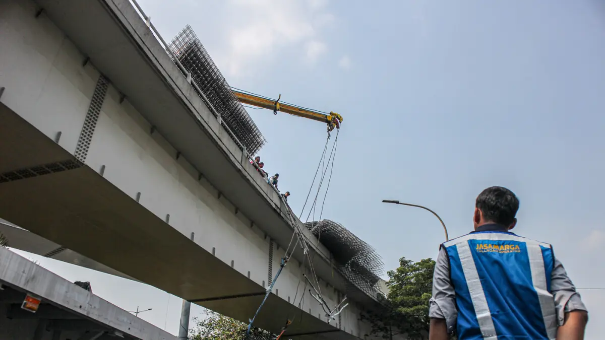 Petugas mengevakuasi muatan truk berupa wiremesh yang tumpah setelah terlibat kecelakaan tunggal di Jalan Tol Tomang, Jakarta, Rabu (24/06/2026). (Hanung Hambara/Jawa Pos)