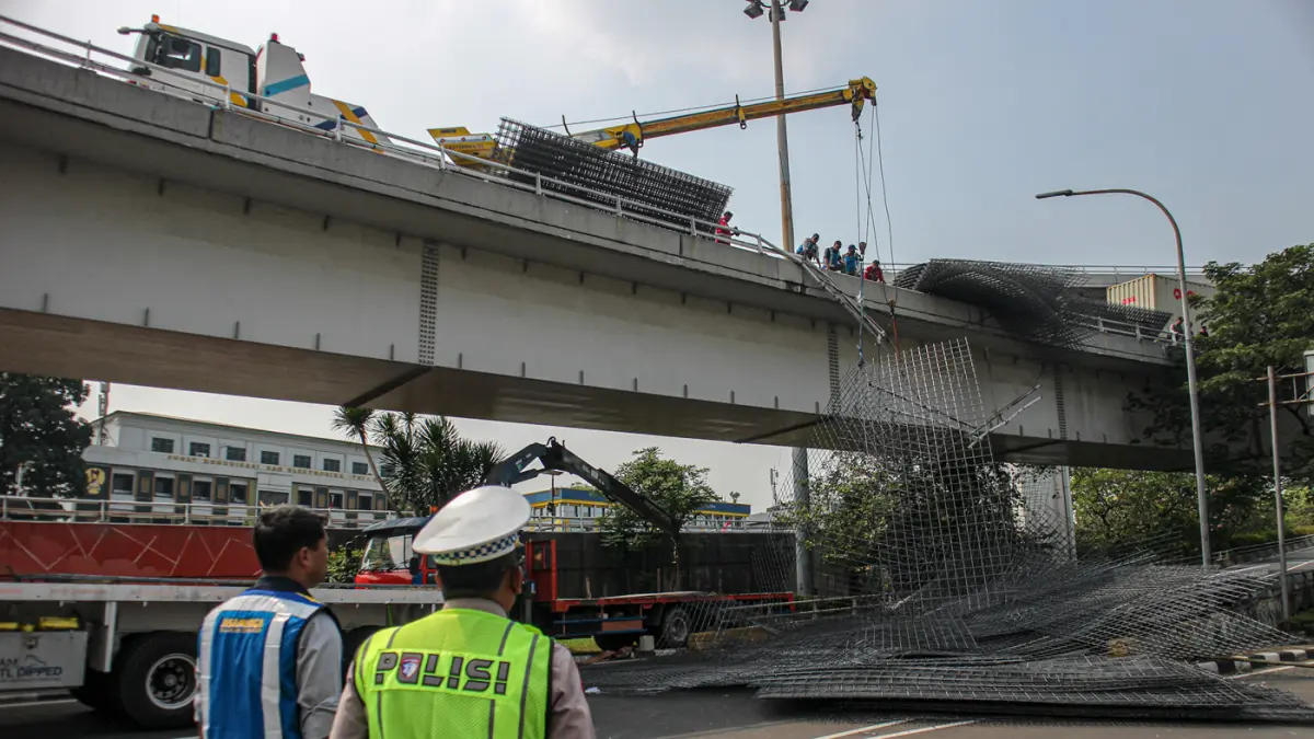 Petugas mengevakuasi muatan truk berupa wiremesh yang tumpah setelah terlibat kecelakaan tunggal di Jalan Tol Tomang, Jakarta, Rabu (24/06/2026). (Hanung Hambara/Jawa Pos)
