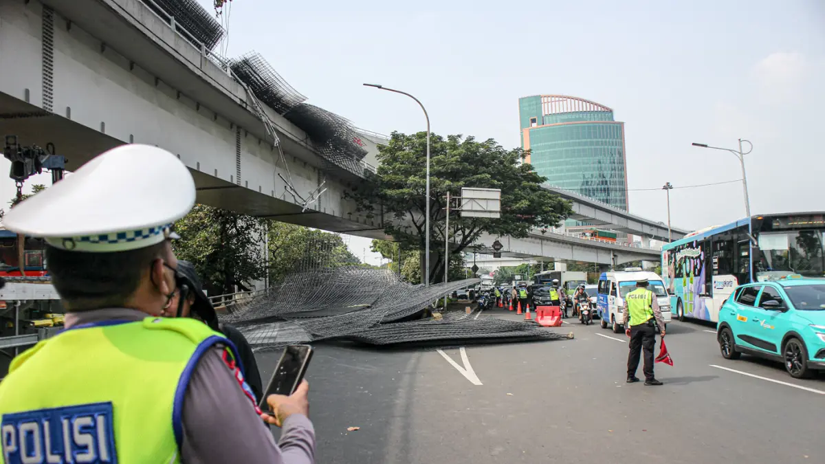 Petugas mengevakuasi muatan truk berupa wiremesh yang tumpah setelah terlibat kecelakaan tunggal di Jalan Tol Tomang, Jakarta, Rabu (24/06/2026). (Hanung Hambara/Jawa Pos)