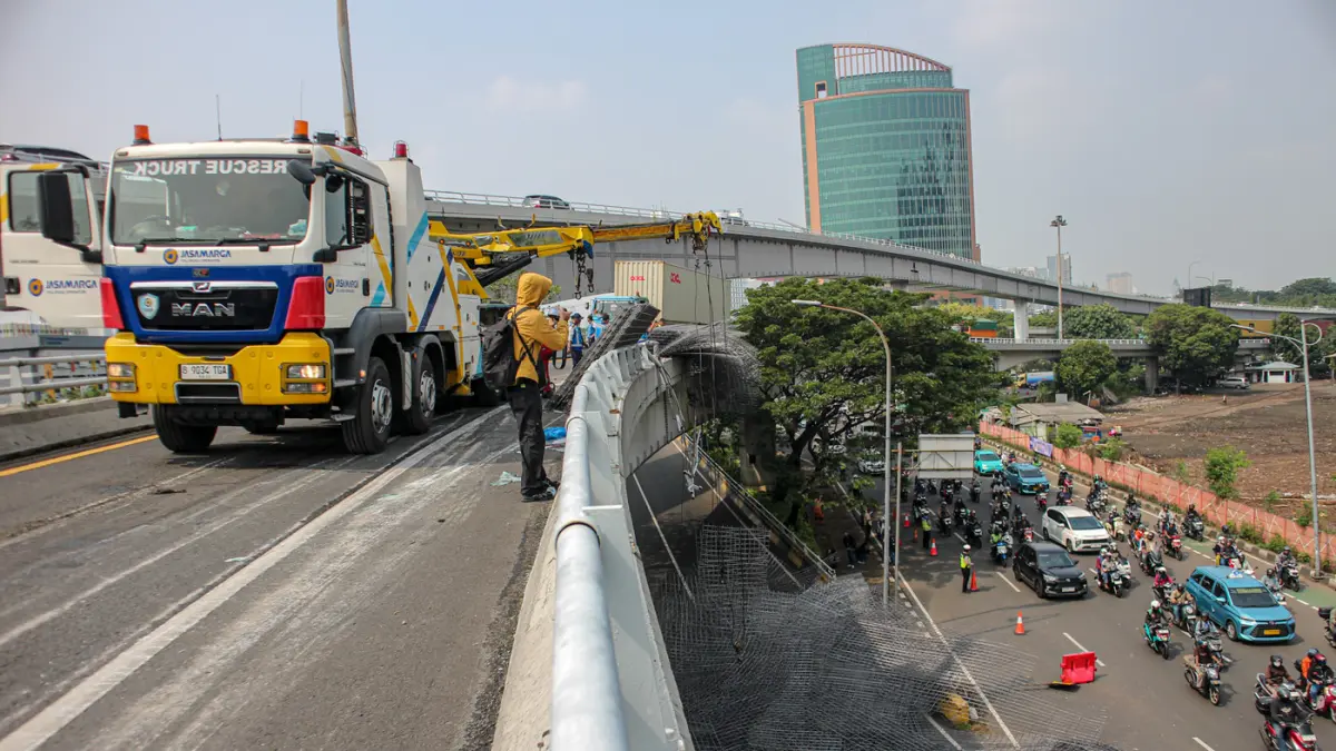 Petugas mengevakuasi muatan truk berupa wiremesh yang tumpah setelah terlibat kecelakaan tunggal di Jalan Tol Tomang, Jakarta, Rabu (24/06/2026). (Hanung Hambara/Jawa Pos)