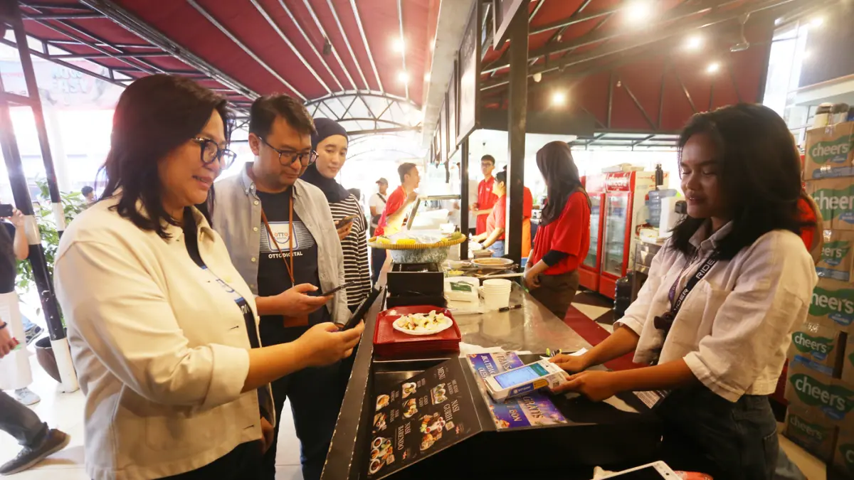 Chief Product Officer OttoDigital Group, Murti Daryandono bersama Chief Revenue Officer OttoDigital Group Grace Sunarjo bertransaksi menggunakan layanan EDC saat Jakarta Fair Kemayoran (JFK) 2026