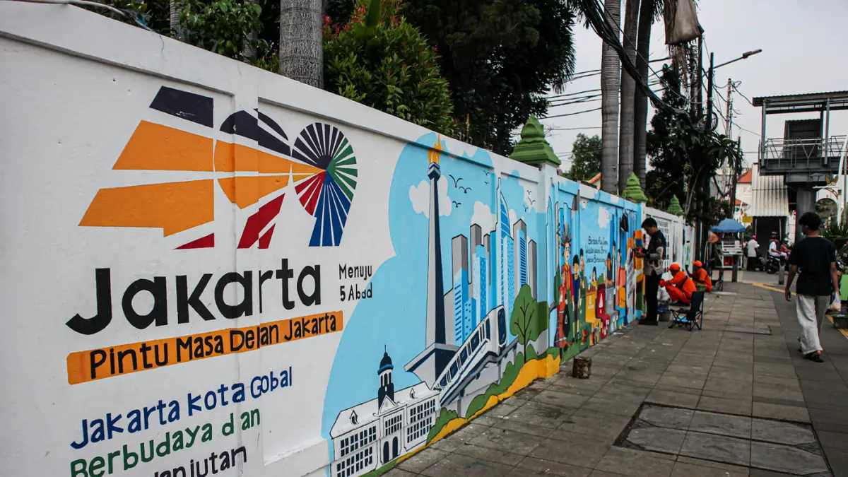 Petugas PPSU Kelurahan Balimester membuat mural di sebuah dinding di jalur pedestrian Jalan Matraman Raya, Jatinegara, Jakarta, Kamis (25/06/2026). (Hanung Hambara/Jawa Pos)