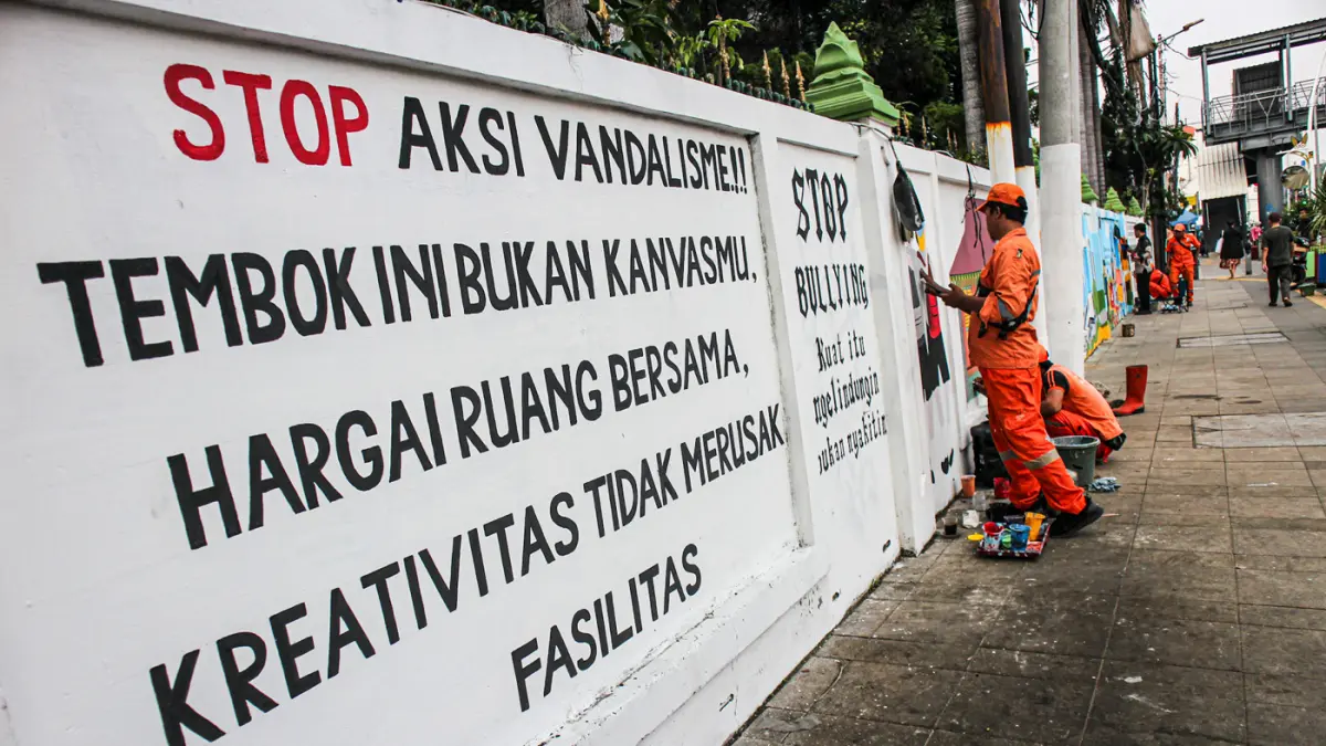 Petugas PPSU Kelurahan Balimester membuat mural di sebuah dinding di jalur pedestrian Jalan Matraman Raya, Jatinegara, Jakarta, Kamis (25/06/2026). (Hanung Hambara/Jawa Pos)
