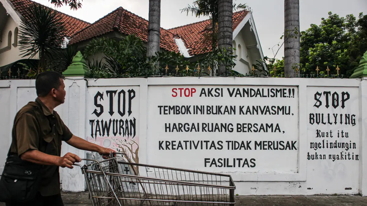 Petugas PPSU Kelurahan Balimester membuat mural di sebuah dinding di jalur pedestrian Jalan Matraman Raya, Jatinegara, Jakarta, Kamis (25/06/2026). (Hanung Hambara/Jawa Pos)