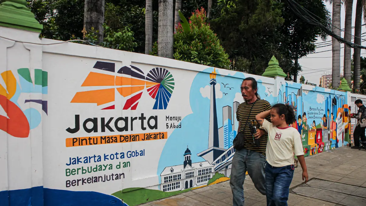 Petugas PPSU Kelurahan Balimester membuat mural di sebuah dinding di jalur pedestrian Jalan Matraman Raya, Jatinegara, Jakarta, Kamis (25/06/2026). (Hanung Hambara/Jawa Pos)
