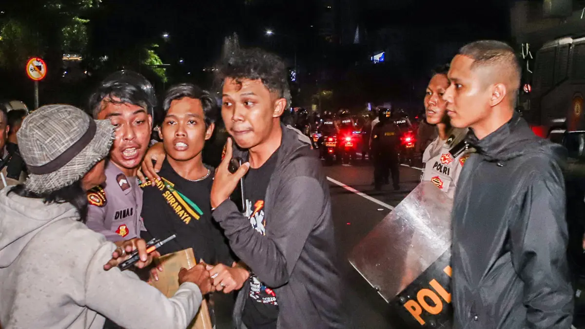 Petugas kepolisian menangkap sejunalh massa aksi yang diduga melakukan tindakan kerusuahan usai mengkritisi kebijakan pemerintah salah satunya program MBG di Gedung Negera Grahadi, Jalan Gubernur Suryo, Surabaya, Jawa Timur, Jumat (26/6/2026). (Riana Seti
