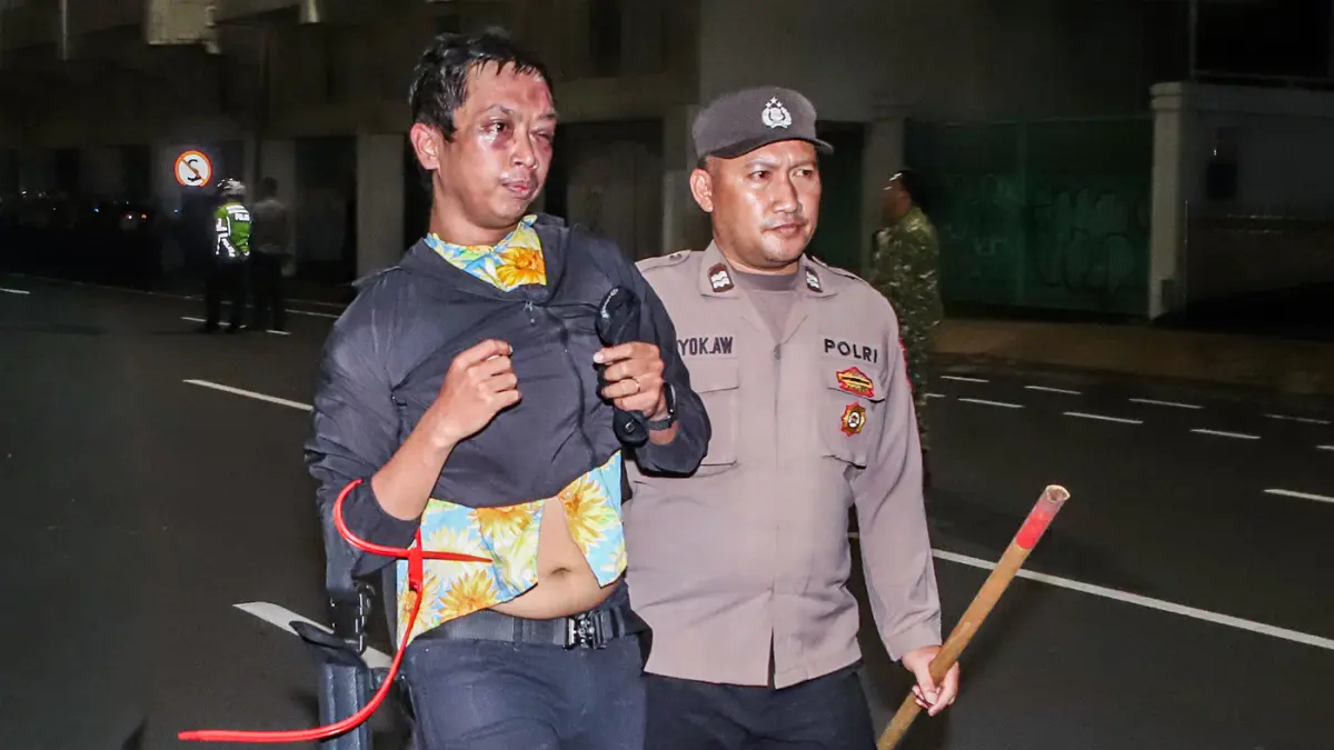 Petugas kepolisian menangkap sejunalh massa aksi yang diduga melakukan tindakan kerusuahan usai mengkritisi kebijakan pemerintah salah satunya program MBG di Gedung Negera Grahadi, Surabaya, Jawa Timur, Jumat (26/6/2026). (Riana Setiawan/ Jawa Pos)